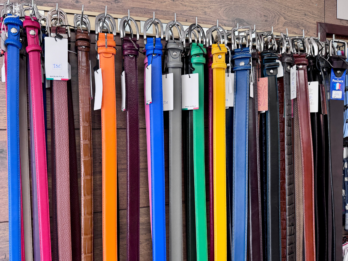 Sélection de ceintures en cuir colorées suspendues en boutique